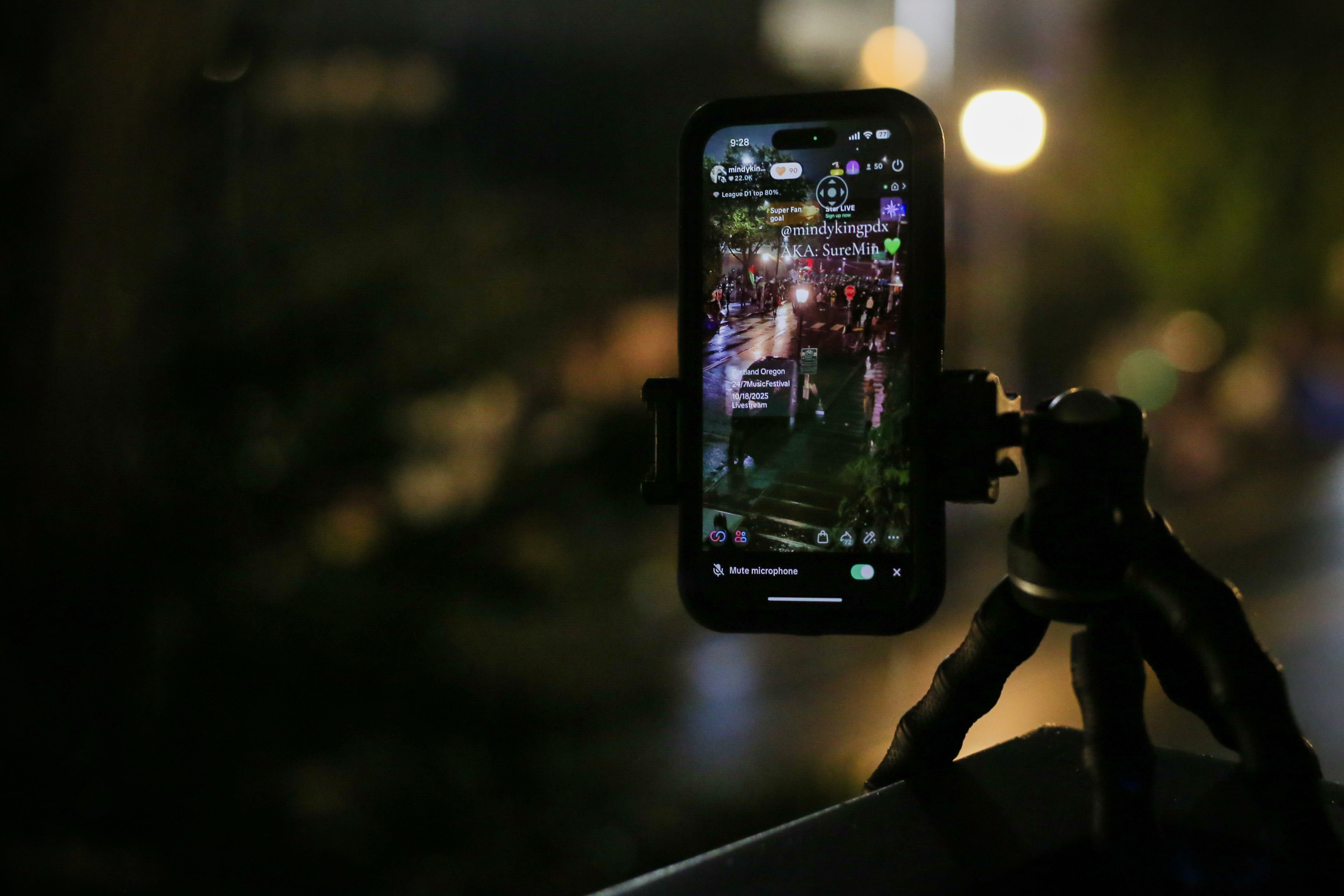 Mindy King streams the protest outside the U.S. Immigration and Customs Enforcement building down the street from her apartment in South Portland on Saturday, Oct. 18, 2025.