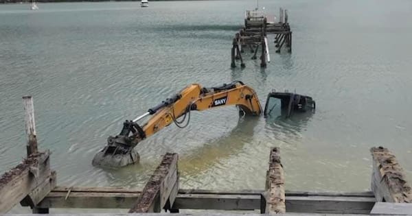 The little yellow digger that... went for a swim at Waitaria Bay jetty
