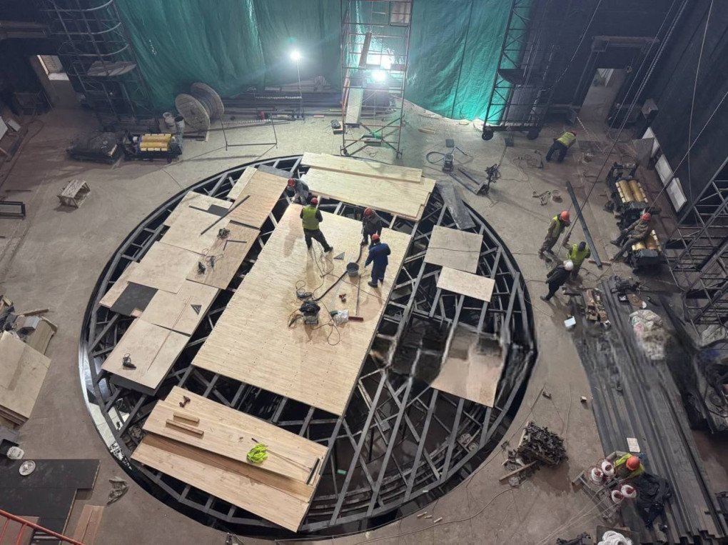 Workers assemble a circular stage platform during the interior reconstruction of the Mariupol Drama Theatre. (Source: Telegram / Mariupol City Council)