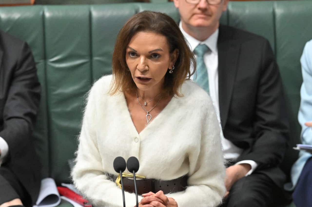 A woman speaks at a microphone standing up