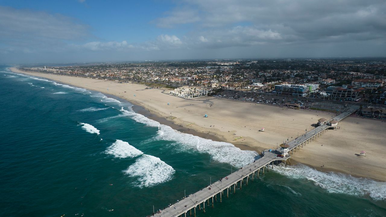 This aerial photo shows a reopened beach in Huntington Beach, Calif., Monday, Oct. 11, 2021. (AP Photo/Ringo H.W. Chiu)