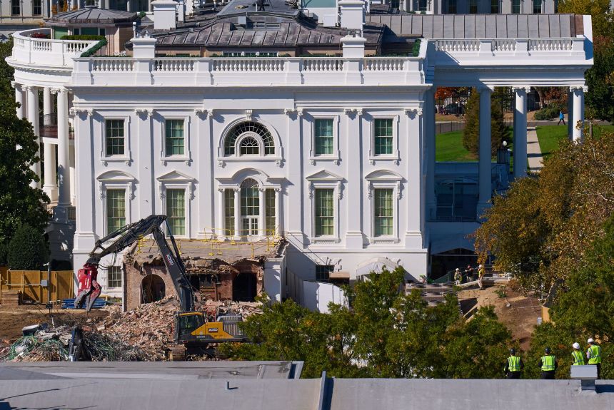 Construction workers, bottom right, stand atop the US Treasury building and watch as demolition work continues on the East Wing of the White House on Thursday, October 23. The demolition is part of President Donald Trump's plan to build a ballroom on the eastern side of the White House.