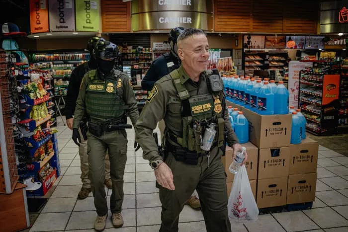 Law enforcement officers in tactical gear, including helmets and vests, walk through a store carrying items