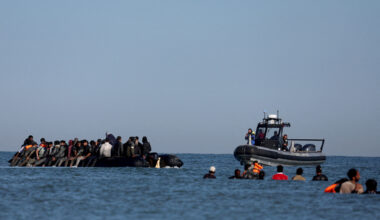 French gendarmes on a boat approach a group of migrants travelling on an inflatable dinghy leaving the coast of northern France in an attempt to cross the English Channel to reach Britain, from the beach of Petit-Fort-Philippe in Gravelines, near Calais, France, Aug. 25. [REUTERS/YONHAP]