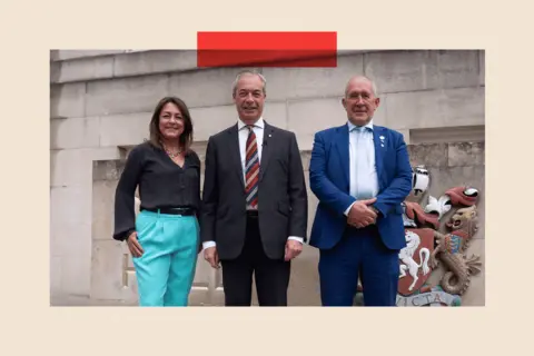 Gareth Fuller / PA Reform UK leader Nigel Farage in the middle and (left to right) the Head of Kent County Council, Linden Kemkaran and councillor Brian Collins pose for a photo