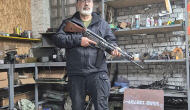 A veteran from the Ukrainian Army, standing in a workshop with a German STG (MP-43 or 44) assault rifle which is chambered in (7.92x33mm) Kurz