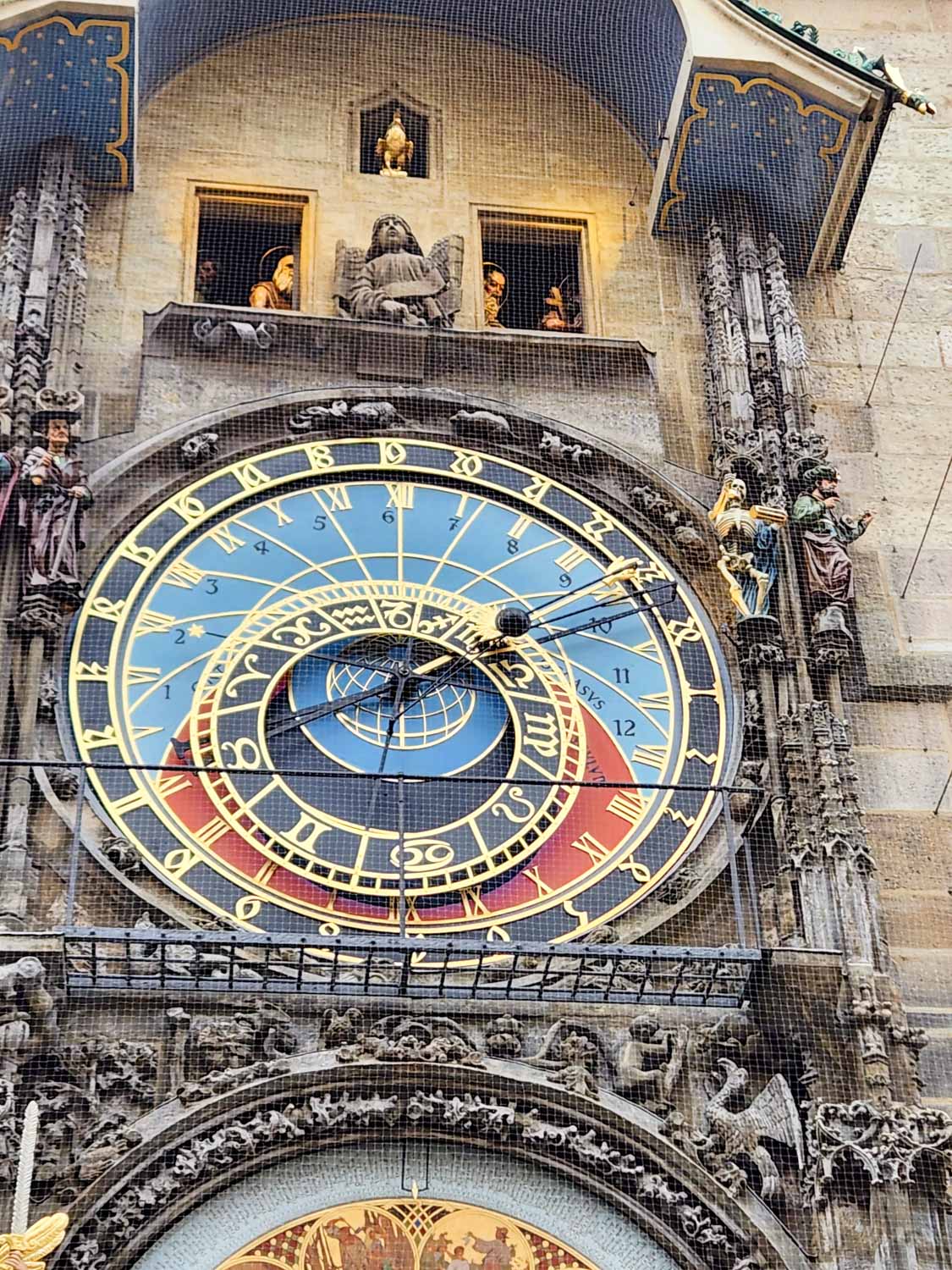 Close-up of the top face and some of the statues of the astronomical clock - one of the unmissable sights of Prague with kids