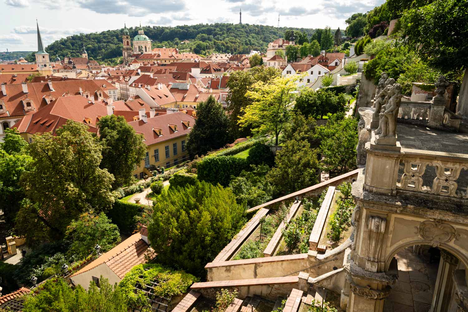 View over the Palace Gardens below Prague Castle towards the dome of St Nicholas Church and Petrin Hill - one of the sites to explore in Prague with kids