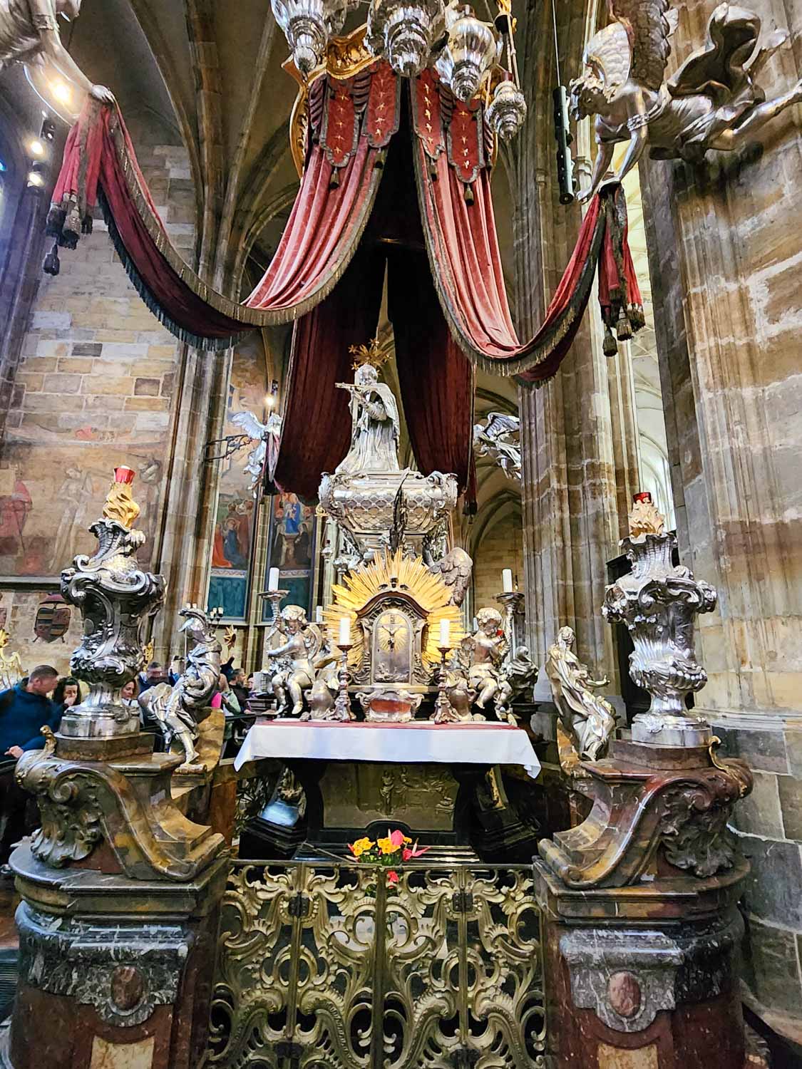 Ornate Baroque tomb of Saint John of Nepomuk inside the St. Vitus Cathedral in the Prague castle complex - one of the historic places to visit in Prague with kids