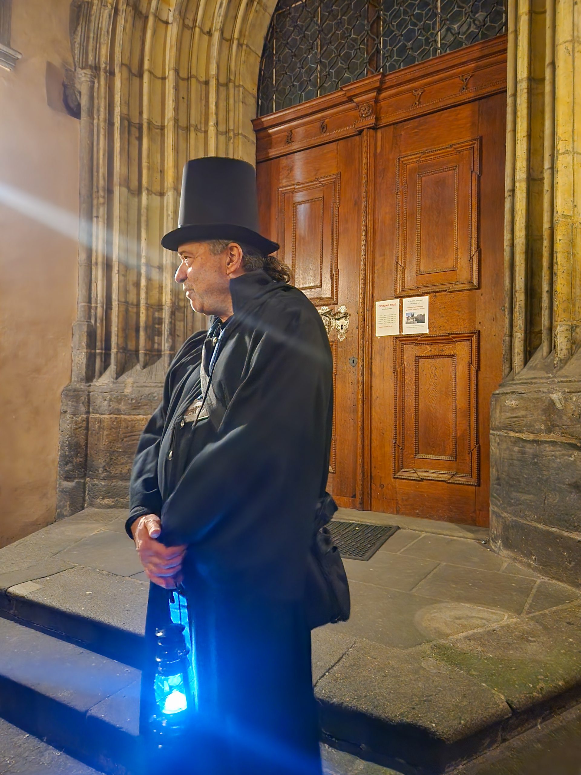 The tour guide in black and top hat with lantern on our ghost tour of Prague - one of the unusual things to do in Prague with kids