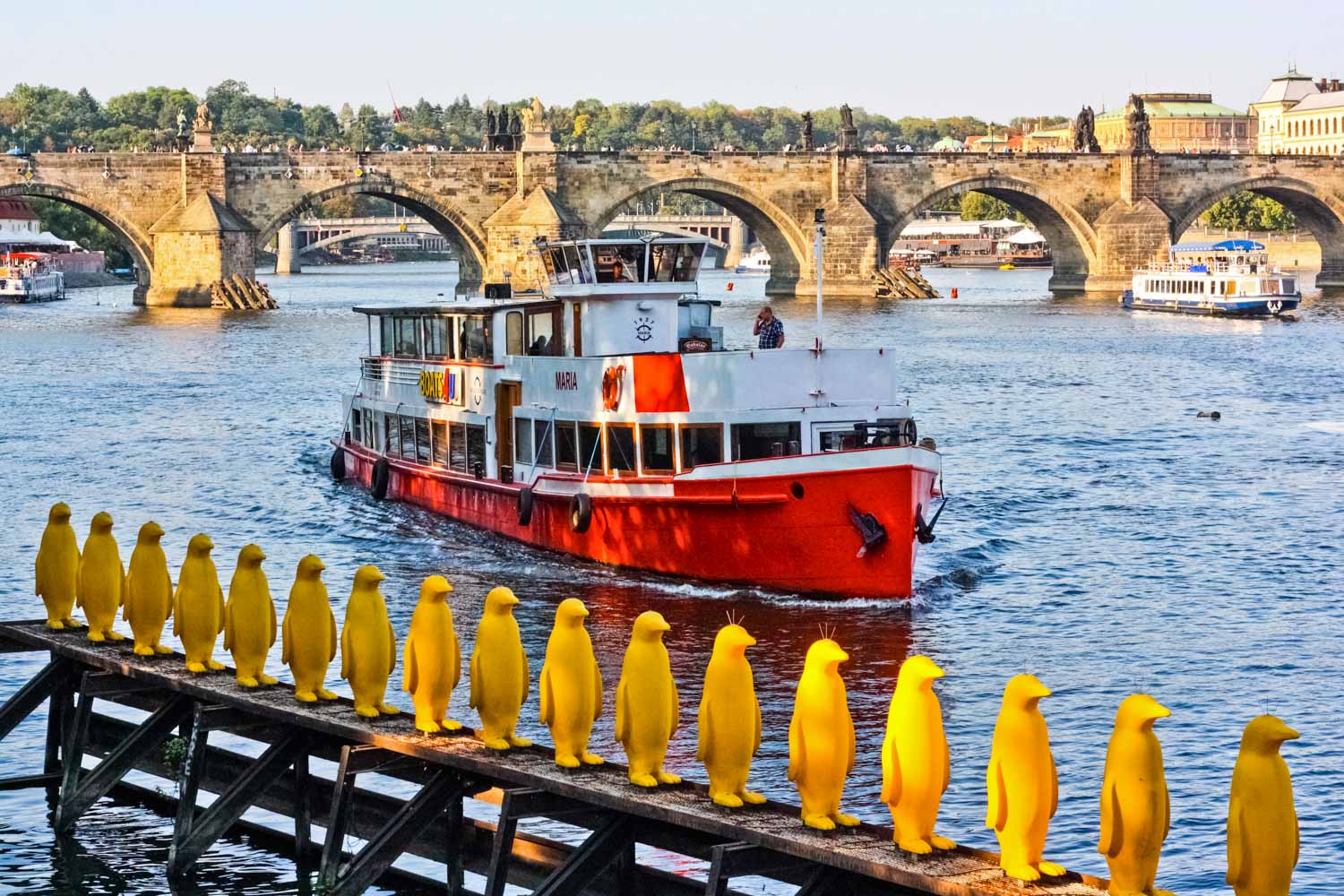Yellow penguin sculptures on the banks of the river by Kampa Island and Museum - one of the unusual places to explore in Prague with kids