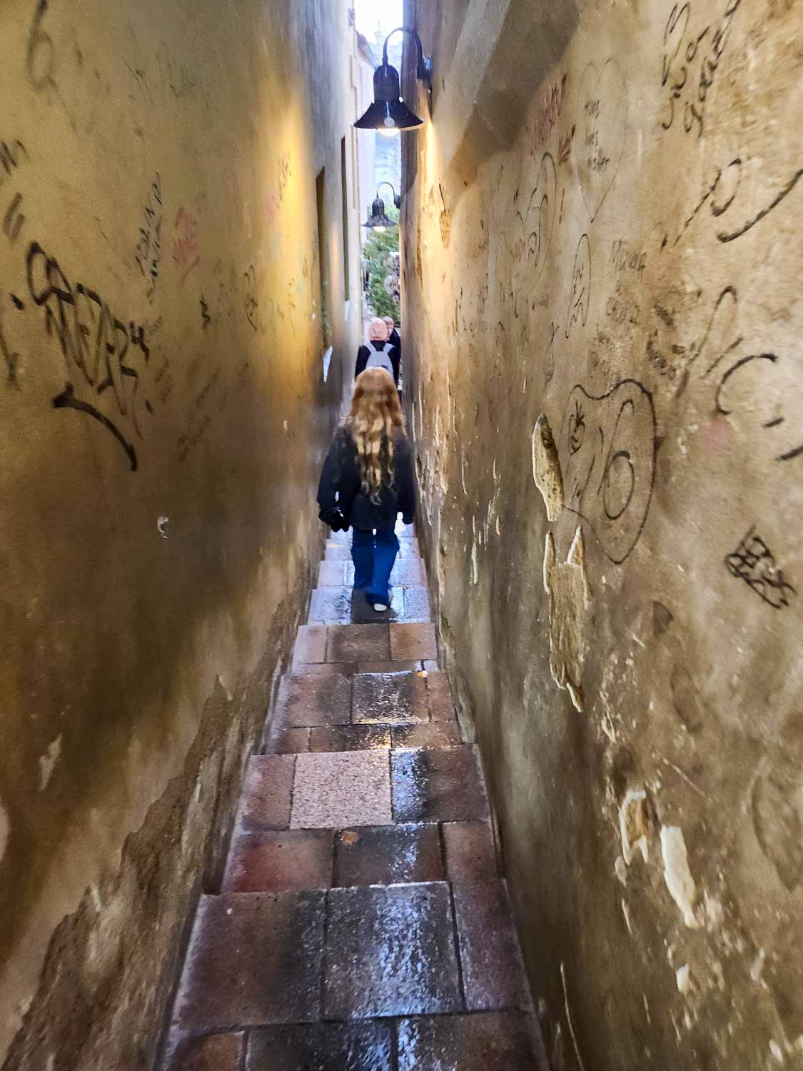 My daughter walks through Prague's narrowest alley - one of the quirky things to do in Prague with children
