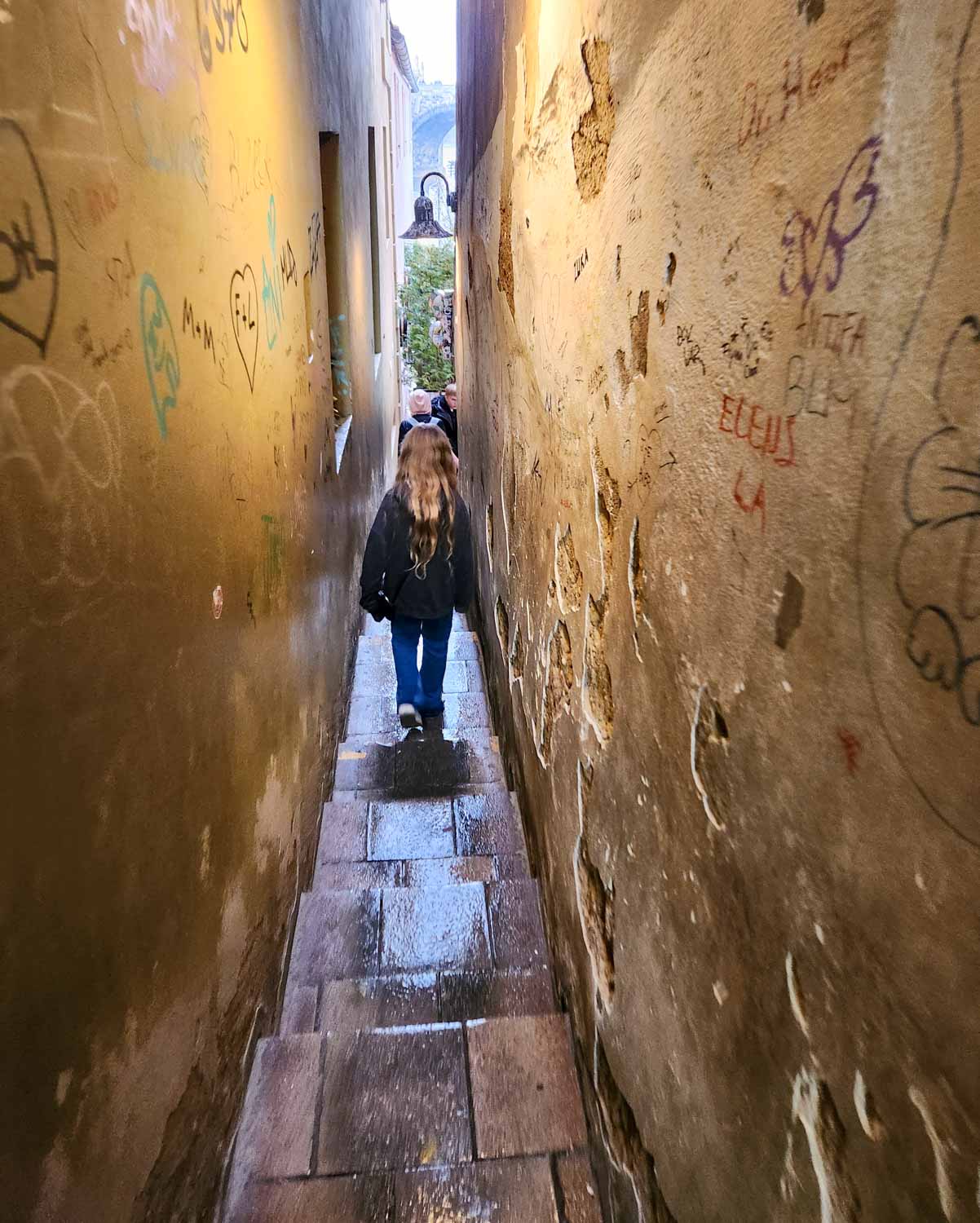 My daughter walks through Prague's narrowest alley - one of the quirky things to do in Prague with children
