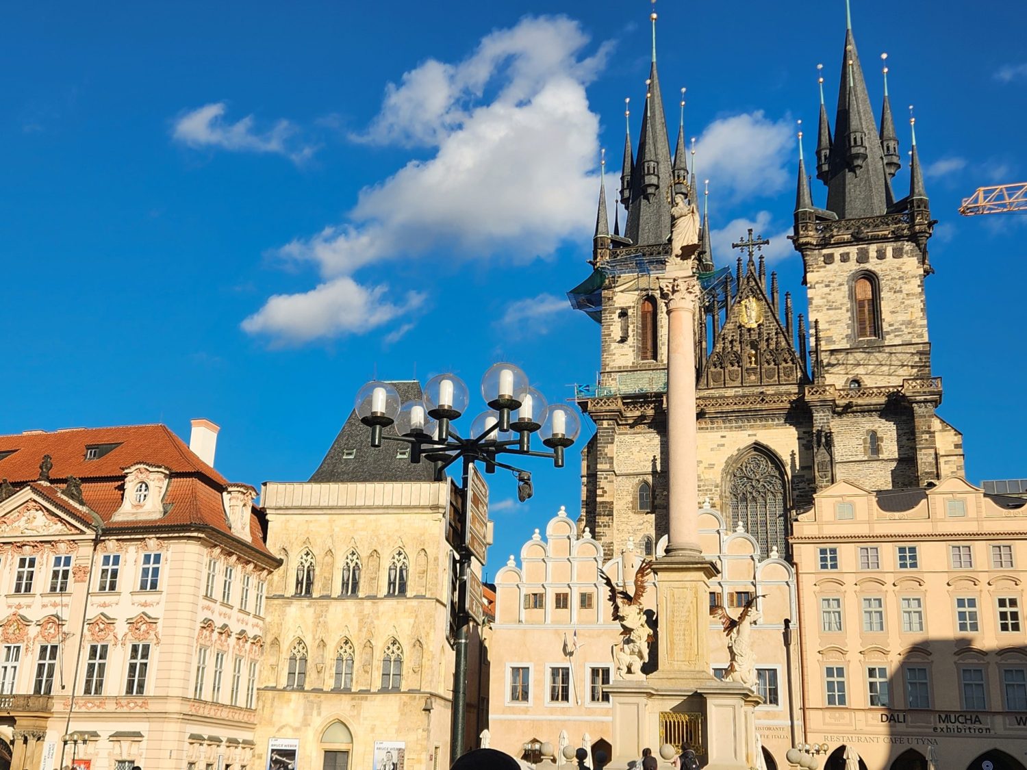 View of the Tyn church and other historic buildings, as well as the Marian column, in the Old Town Square - one of the best places to visit in Prague with kids