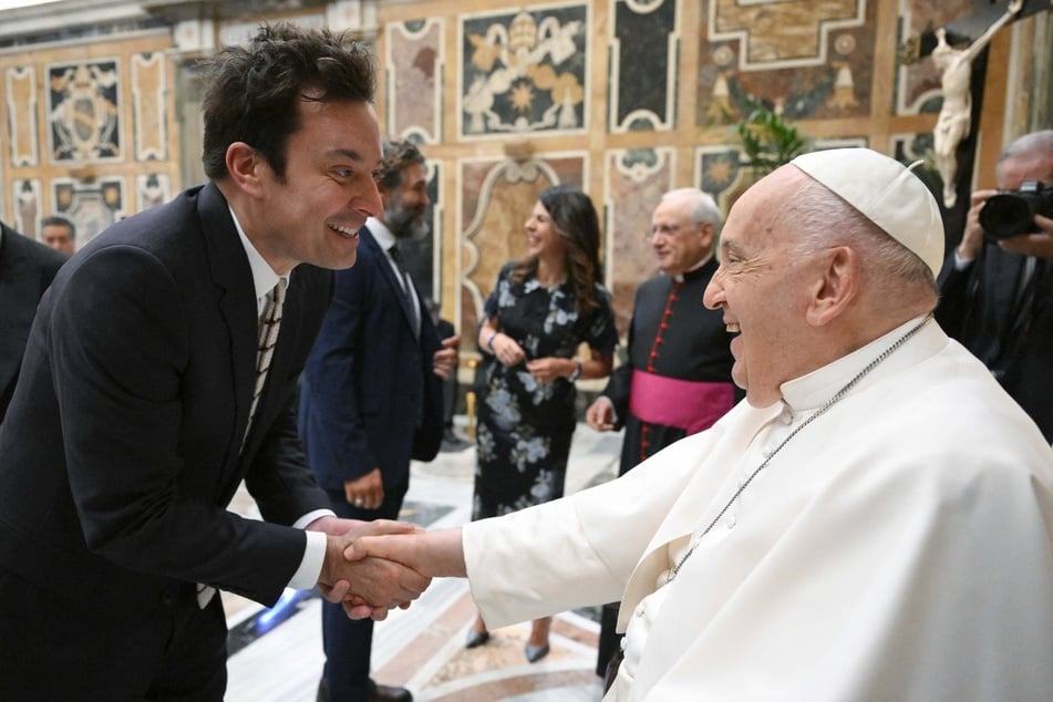 This photo taken and handout on June 14, 2024 by The Vatican Media shows Pope Francis shaking hand with actor Jimmy Fallon as part of an audience with comedians in The Vatican.