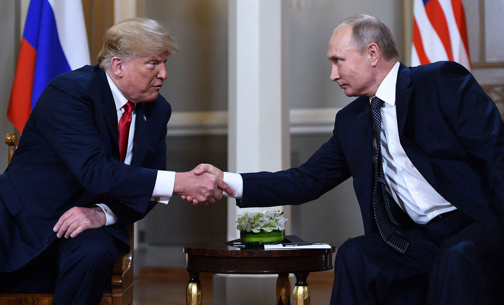 Russian President Vladimir Putin (R) and US President Donald Trump shake hands before a meeting in Helsinki, on July 16, 2018. (BRENDAN SMIALOWSKI/AFP via Getty Images)