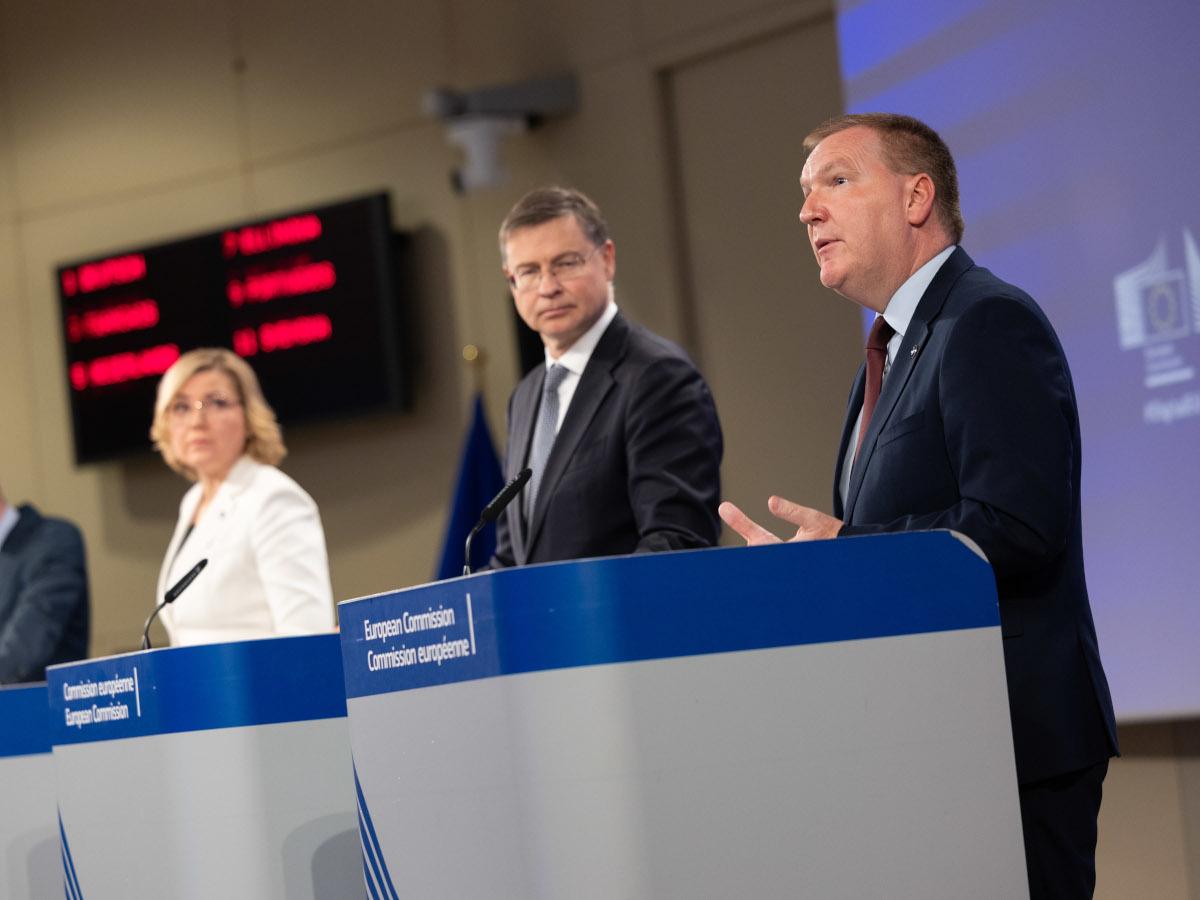 Henna Virkkunen, Valdis Dombrovskis and Michael McGrath stand at a podium at the European Commission.