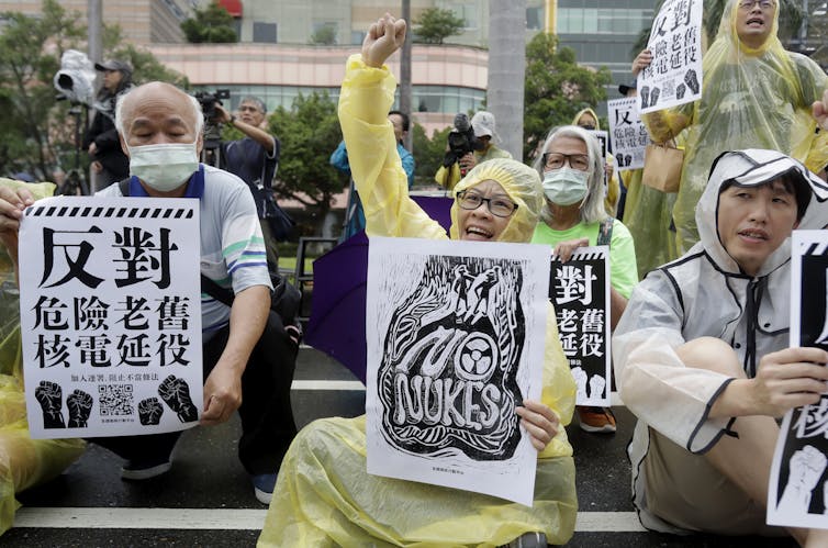 Protesters hold signs, one saying 'no nukes'