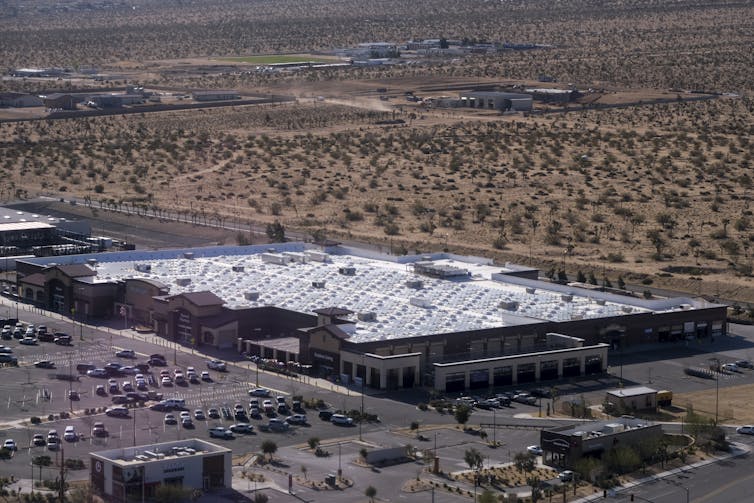 A large Walmart store with the roof shining with solar panels in the sun.