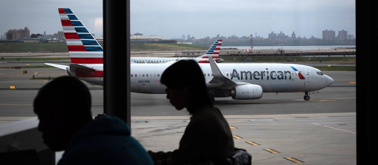 Menschen warten in einem Flughafen-Terminal.