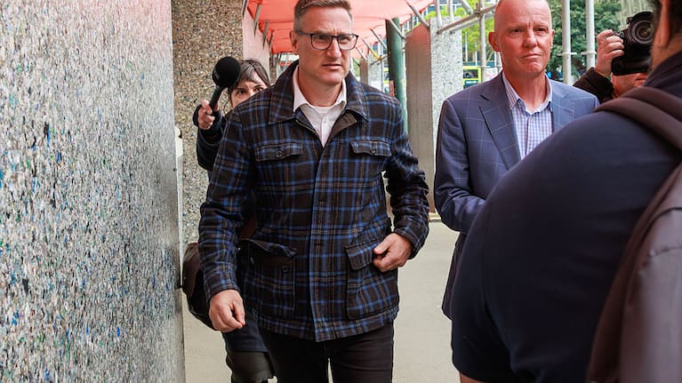 Former Deputy Police Commissioner Jevon McSkimming (wearing glasses) is pursued by media after pleading guilty to eight charges of possessing objectionable publications in the Wellington District Court