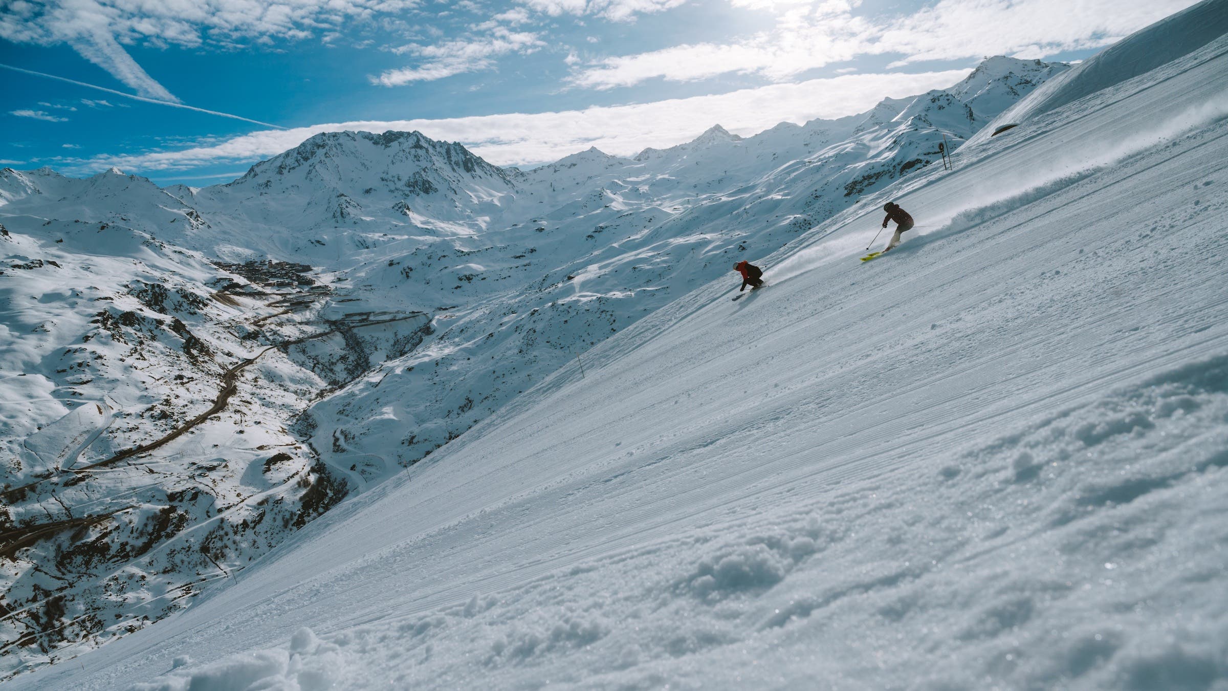 two skiers in mountain on blue bird day