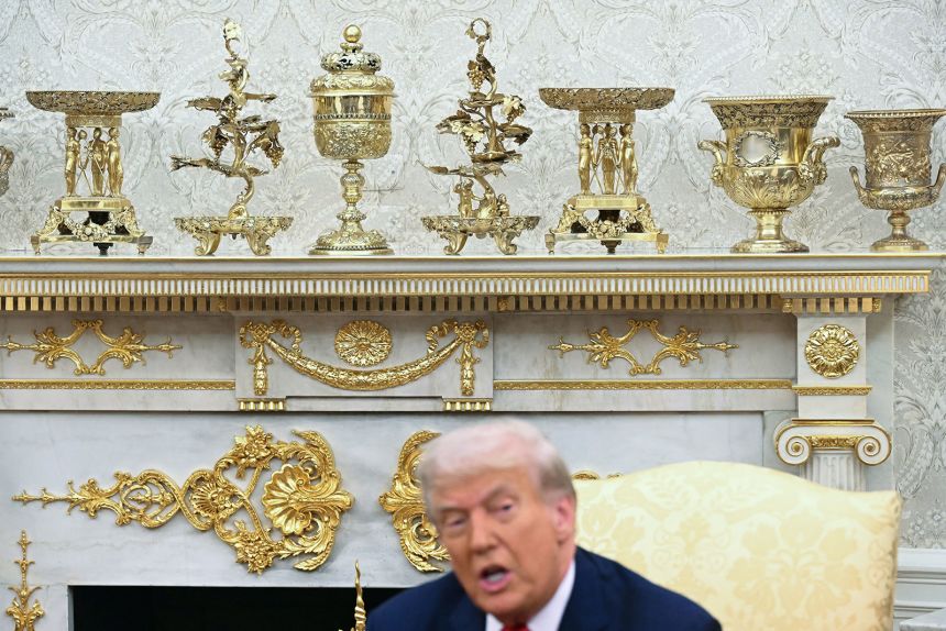 Gold colored ornaments and decor are seen as President Donald Trump speaks in the Oval Office of the White House on September 25.