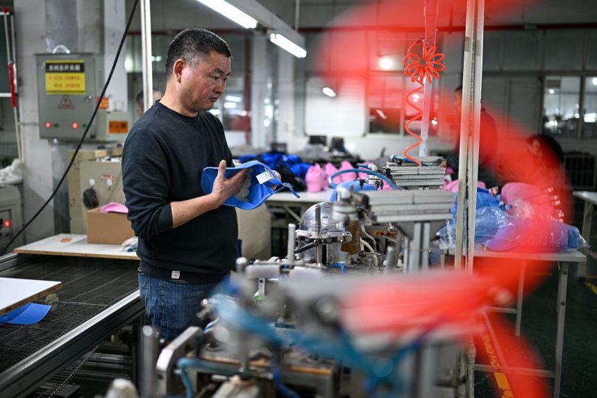 Workers produce hat orders in the production workshop of a factory in China's Jiangsu province last month.