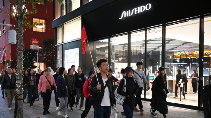 A Chinese tour group walks past a Shiseido store in Tokyo