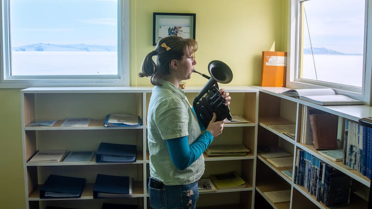 In this photo provided by Antarctica New Zealand, Natalie Paine plays a plastic French horn at Scott Base in Antarctica