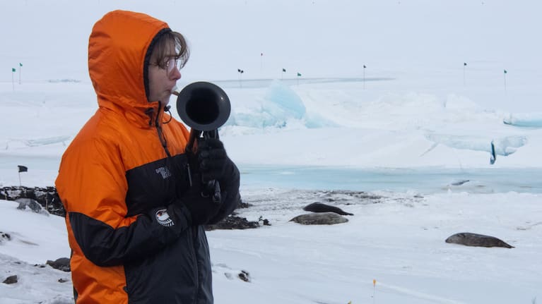 In this photo provided by Antarctica New Zealand, Natalie Paine plays a plastic French horn at Scott Base in Antarctica