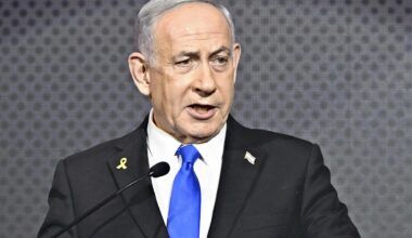 Der israelische Ministerpräsident Benjamin Netanjahu spricht im Anzug vor dunkelgrauem Hintergrund an einem Podium