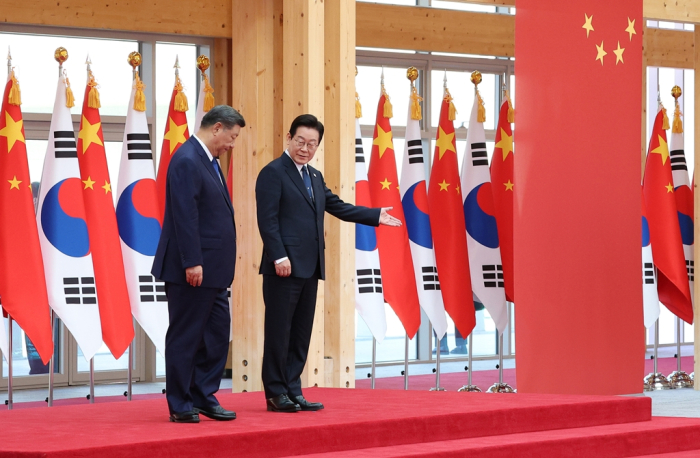 South Korean President Lee Jae Myung (right) and Chinese President Xi Jinping walk together to inspect the honor guard at the official welcoming ceremony at the Gyeongju National Museum