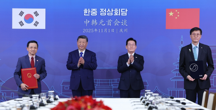 Bank of Korea (BOK) Gov. Lee Chang-yong (right) and Chinese Ambassador to Korea Xing Haiming (left) pose for a photo after signing a won-yuan currency swap on the sidelines of the Lee Jae Myung-Xi Jinping summit in Gyeong