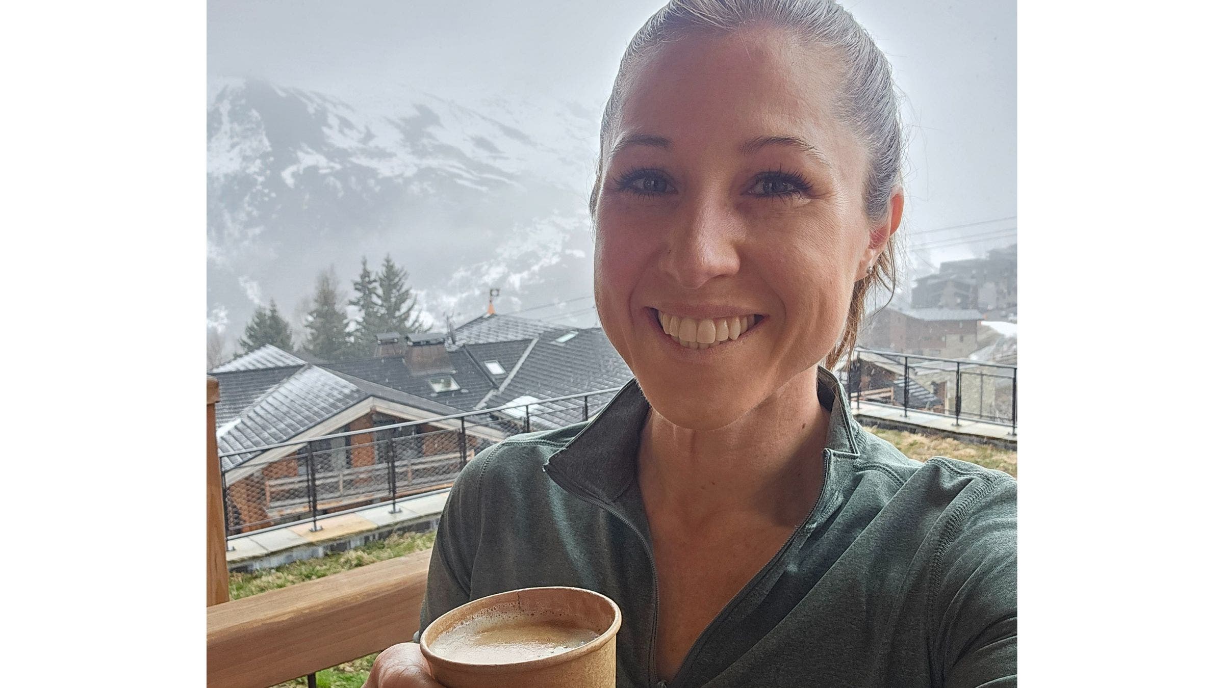 the author posing in front of mountains with drink