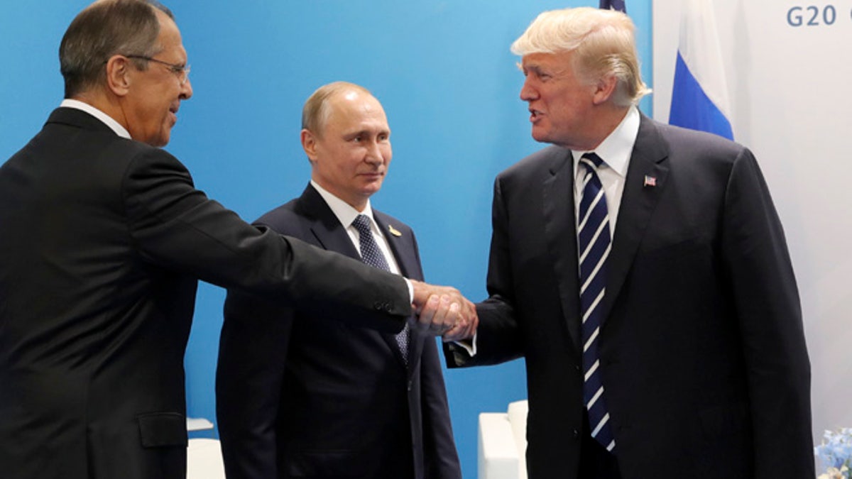 U.S. President Donald Trump, right, greets Russian Foreign Minister Sergey Lavrov, left, prior his talks with Russian President Vladimir Putin, center, during the G20 summit in Hamburg Germany, Friday July 7, 2017. (Mikhail Klimentyev, Kremlin Pool Photo via AP)