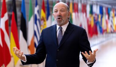 US-Handelsminister Howard Lutnick spricht und gestikuliert im Gebäude des Europäischen Rates in Brüssel. Hinter ihm sind die Flaggen der EU-Staaten.