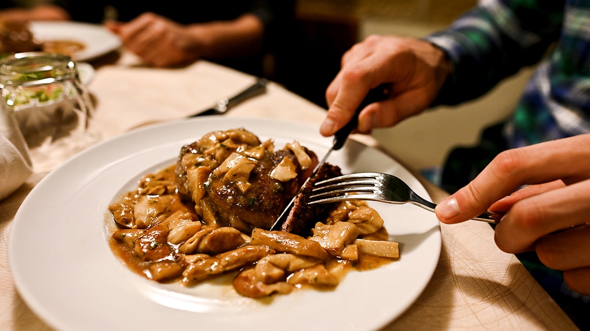 Eating mushrooms on a white plate in a restaurant close up shot