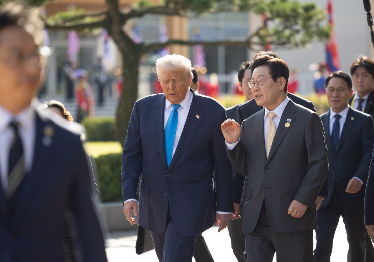 US President Donald Trump (center left) and South Korean President Lee Jae Myung talk as they walk toward the summit venue in Gyeongju, North Gyeongsang Province, Oct. 29. (Yonhap)