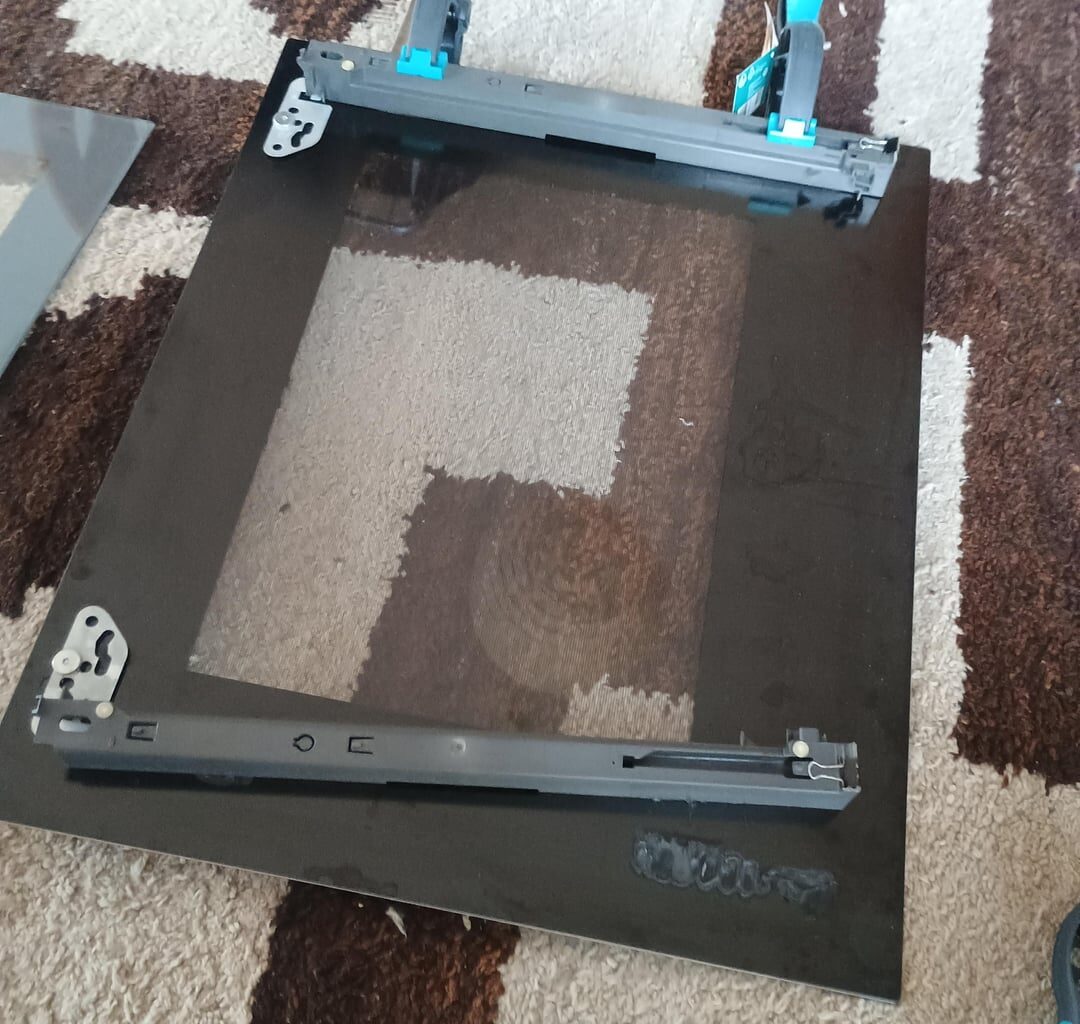 Which adhesive can be used to reattach the outer glass panel of an oven door (max. 270 °C) to its plastic brackets?