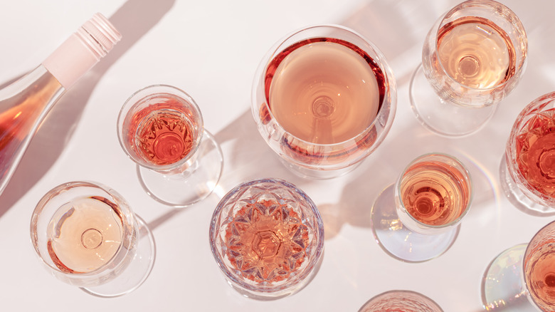 Variety of glasses of rosé next to a bottle of wine