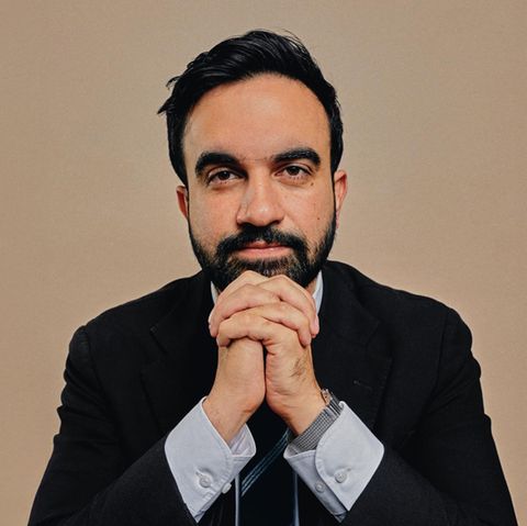Zohran Momdani im Anzug vor einem neutralen Hintergrund