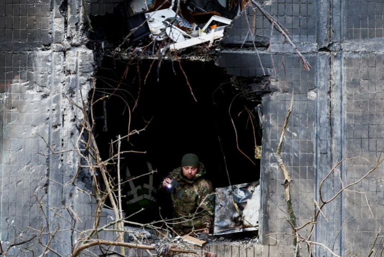 An investigator looks through the window of an apartment building damaged during an overnight Russian drone and missile strike, amid Russia's attack on Ukraine, in Kyiv, Ukraine, November 14, 2025. REUTERS/Thomas Peter TPX IMAGES OF THE DAY