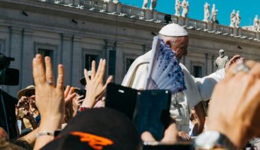 Pope surrounded with people during daytime