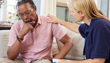 Telling the Hospital Story: Sharon Hospital - Rural Connecticut hospital’s behavioral health unit, meals program support older adults’ well-being; A female carer sits with an older man wearing a troubled expression