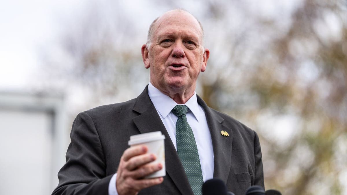Tom Homan speaks to reporters outside the White House holding a coffee cup.