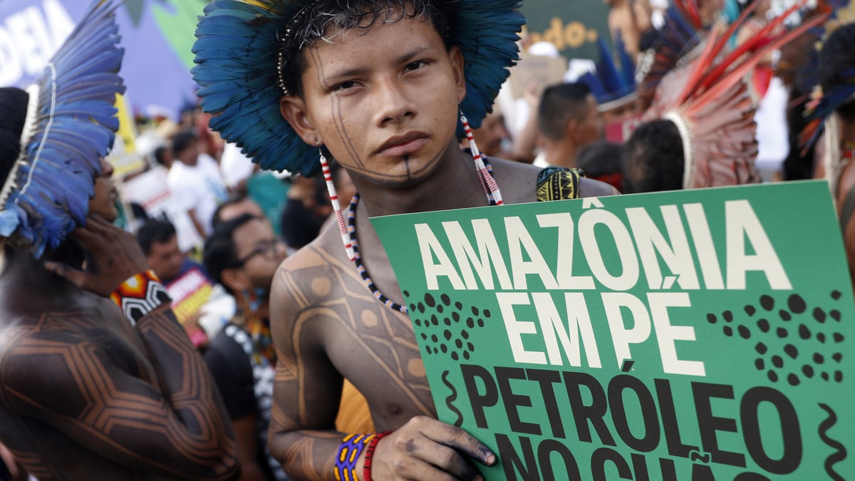 An indigenous boy holds a sign reading “Amazonia stands - oil stays in the ground” during an event calling for climate justice in Belem, Brazil, on Saturday.