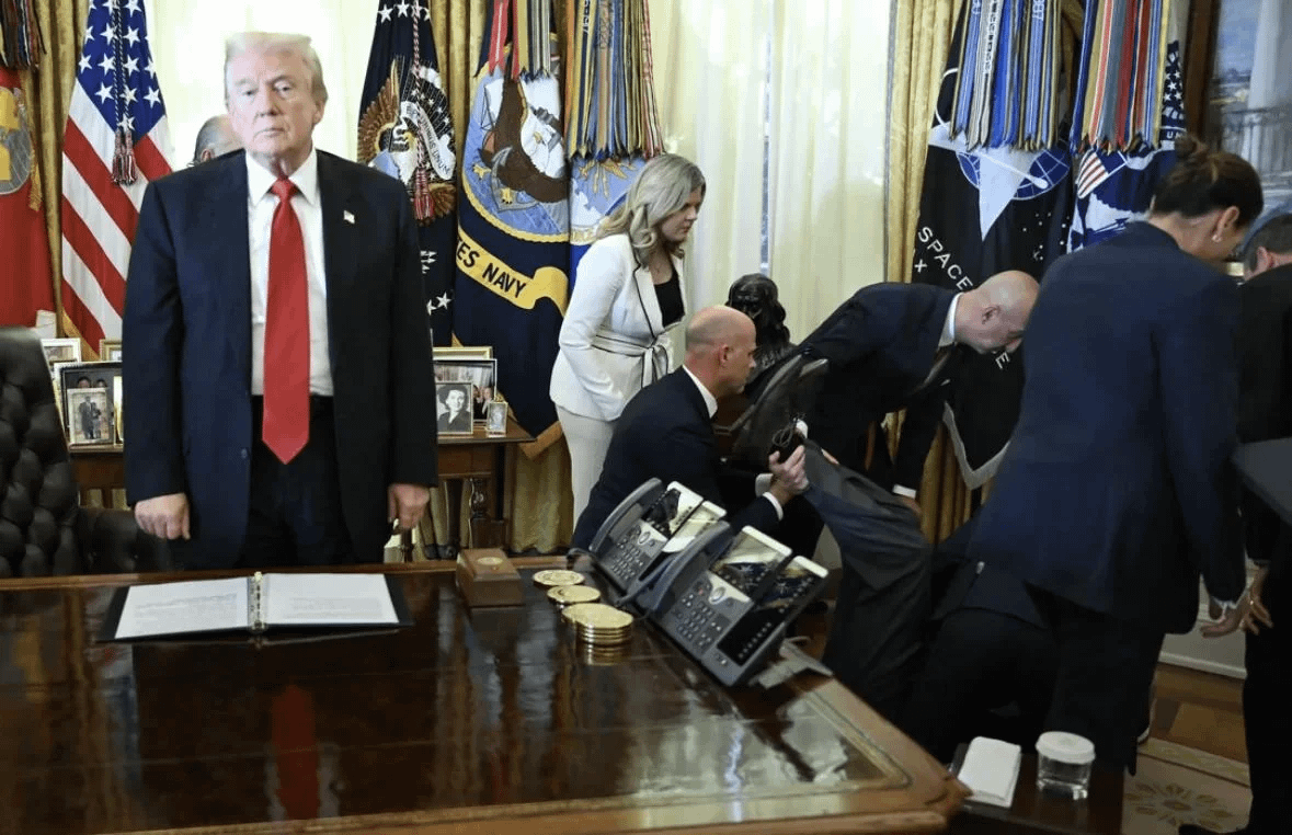 Trump looks on after a man fainted during an announcement in the Oval Office.
