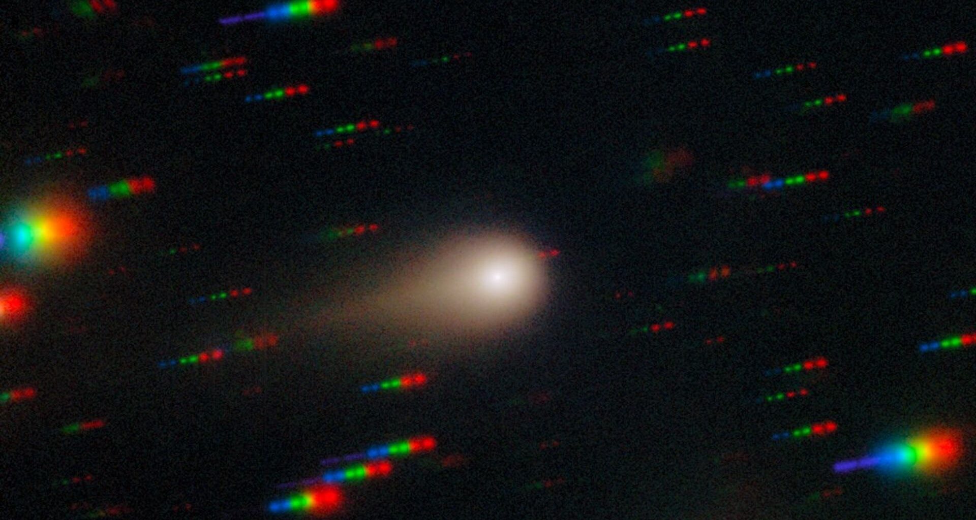 an image of a comet streaking through space with the stars around it reflecting rainbows