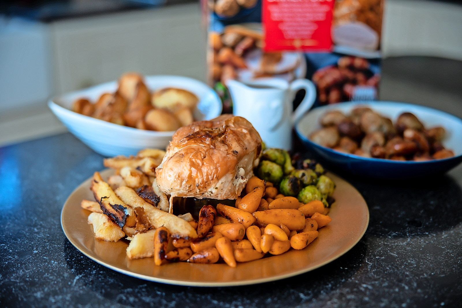 Christmas dinner with roast chicken, roasted potatoes, carrots, and Brussels sprouts.